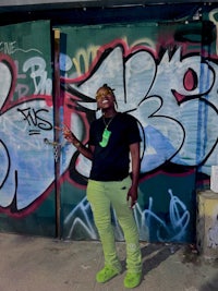 a woman standing in front of a building covered in graffiti